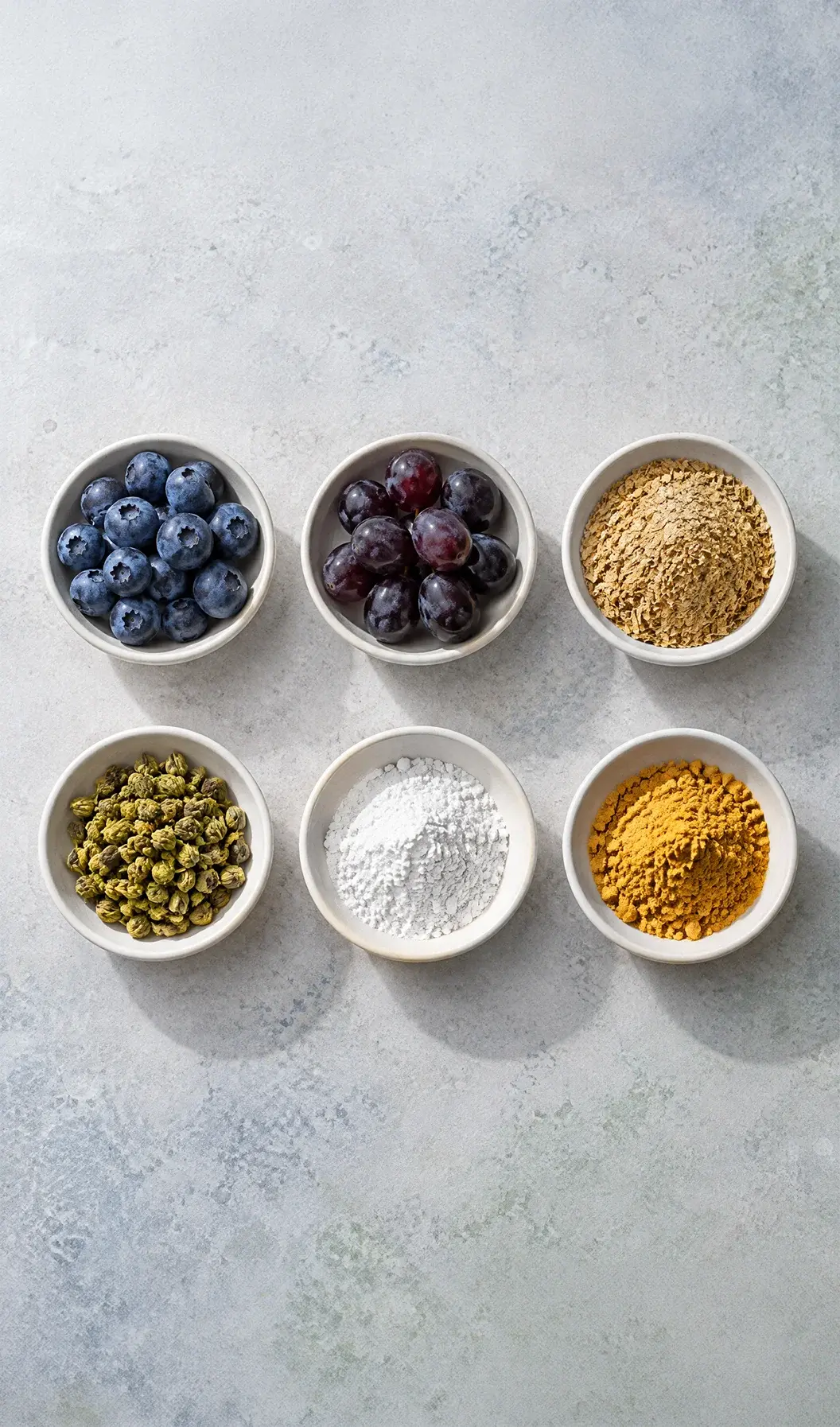 Six bowls of Lujevit active ingredients on a light stone surface